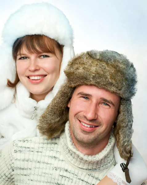 Casal feliz em chapéus de pele quentes — Fotografia de Stock