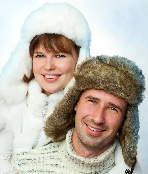 Casal feliz em chapéus de pele quentes — Fotografia de Stock
