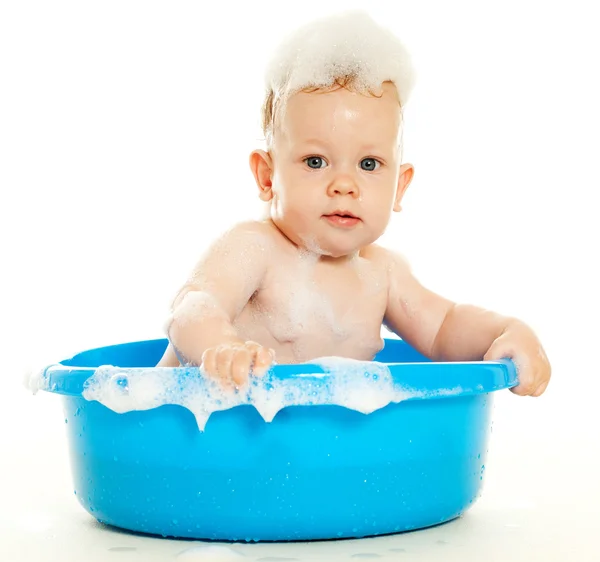Bebê sentado em uma banheira azul — Fotografia de Stock