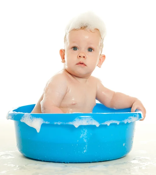 Baby sitting in a blue tub Stock Picture