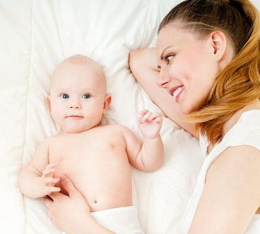 Anne ve bebek oynuyor ve gülümsüyor.