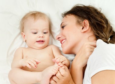 Anne ve bebek oynuyor ve gülümsüyor.
