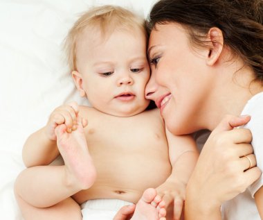 Anne ve bebek oynuyor ve gülümsüyor.