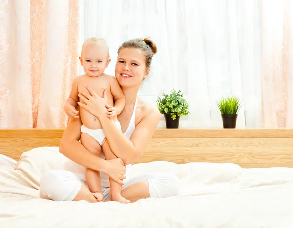 Mutter und Baby spielen im Bett — Stockfoto