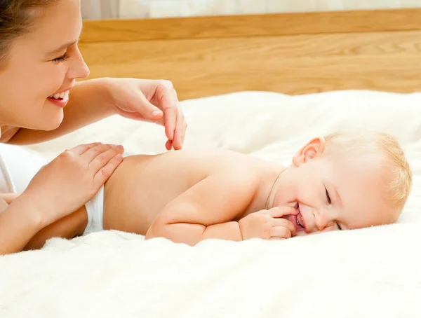 Mutter und Baby spielen im Bett — Stockfoto