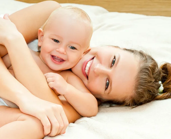 Мать и ребенок играют у кровати — стоковое фото