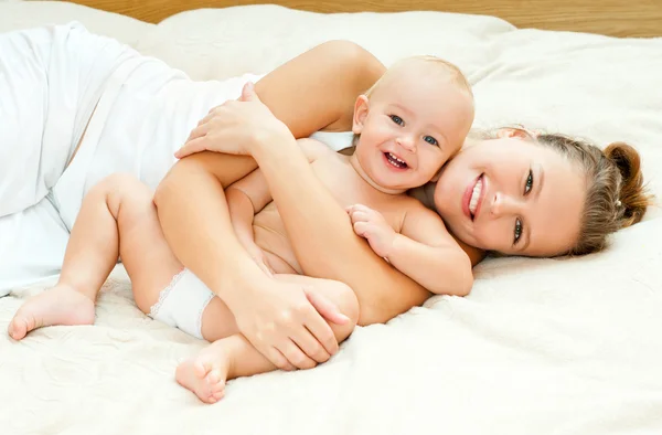 Mutter und Baby spielen im Bett — Stockfoto