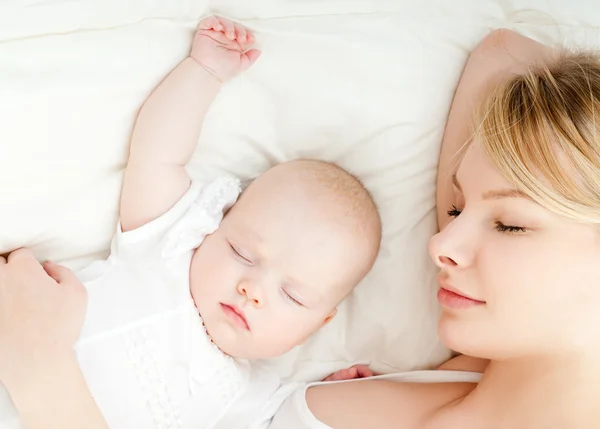 Jovem mãe e seu bebê dormindo na cama — Fotografia de Stock