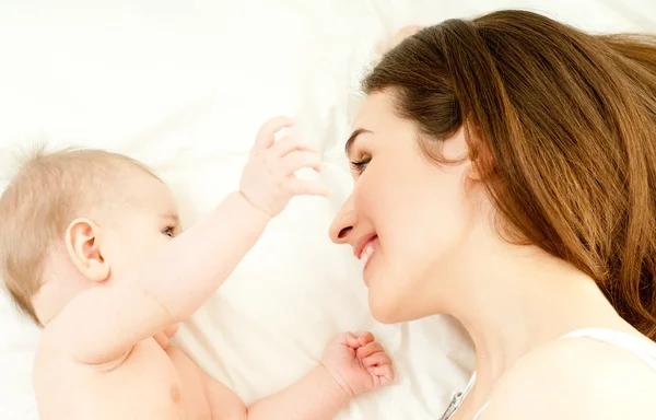 Mãe e bebê brincando na cama — Fotografia de Stock