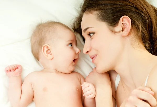 Mutter und Baby spielen im Bett — Stockfoto