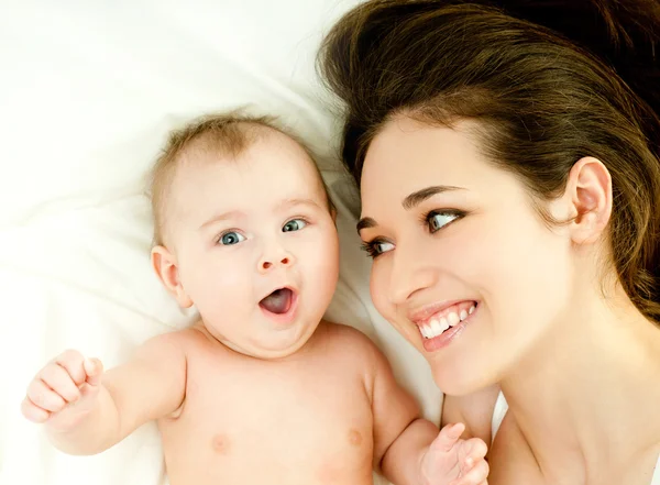 Moeder en baby spelen op bed — Stockfoto