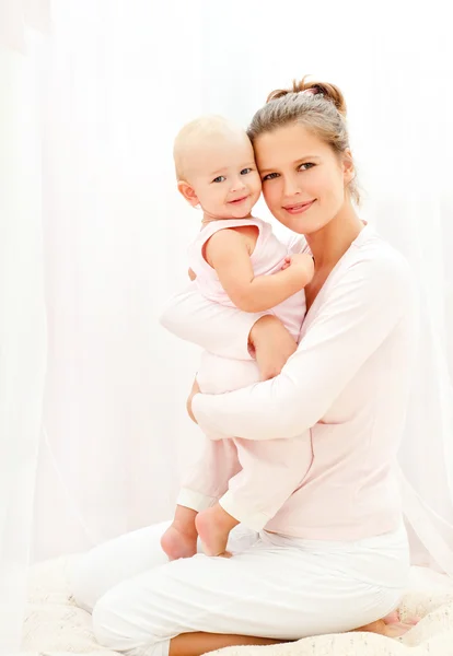 Mãe e bebê brincando na cama — Fotografia de Stock