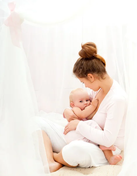Genç breastfeeds bebeği anne.