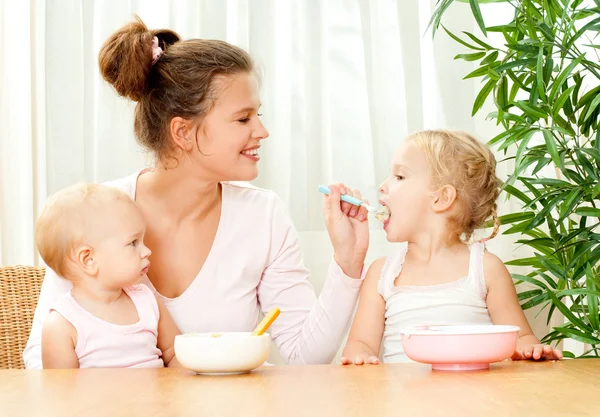 Mutter füttert ihre Töchter — Stockfoto