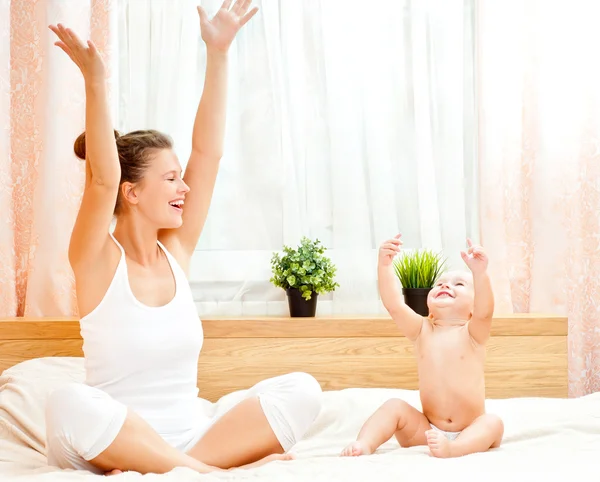 Madre y bebé jugando en la cama — Foto de Stock