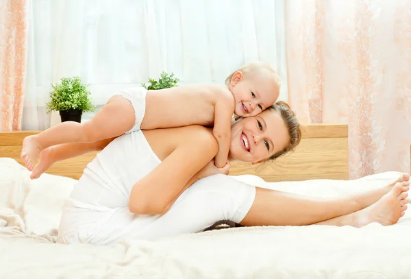 Mutter und Baby spielen im Bett — Stockfoto
