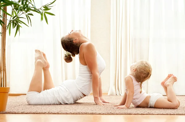 Mor och dotter gör yogaövningar — Stockfoto