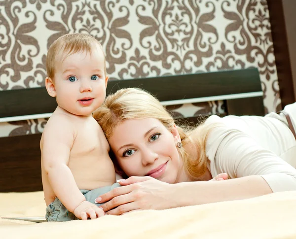 Anne ve bebek yatak oynarken — Stok fotoğraf