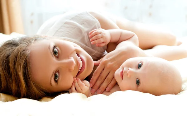 Mãe e bebê relaxando na cama — Fotografia de Stock