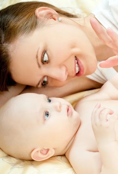 Mãe e bebê relaxando na cama — Fotografia de Stock