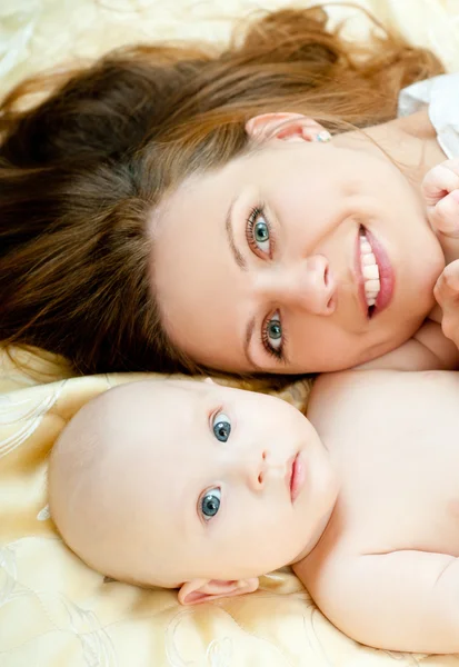 Mère et bébé se relaxent au lit — Photo