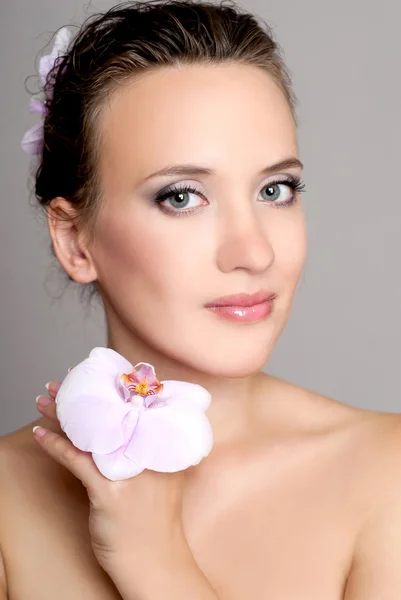 Junge Frau mit Orchidee — Stockfoto