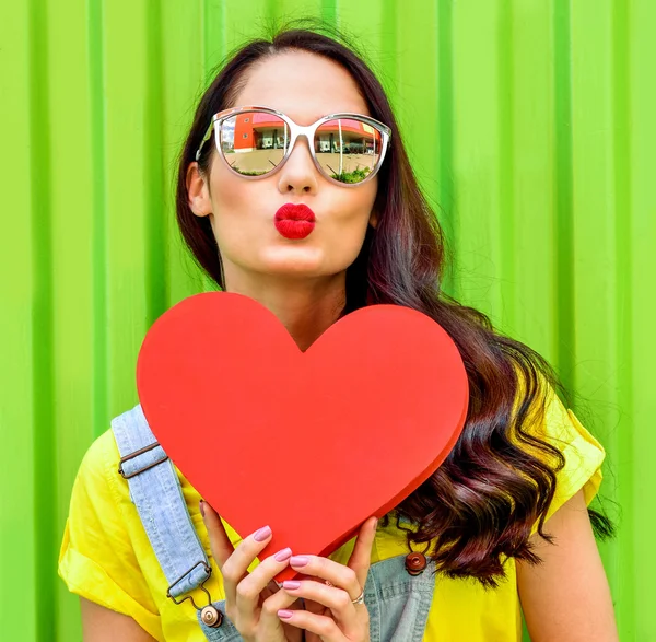 Beautiful woman holding a red heart — Stock Photo, Image