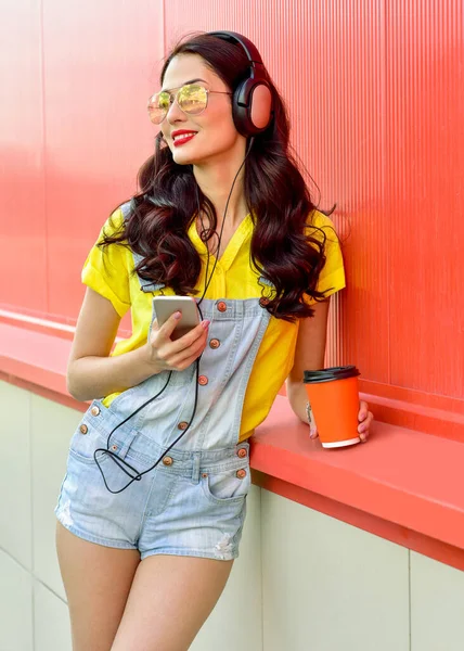 Hermosa Mujer Sonriente Con Auriculares Escucha Música Sobre Fondo Rojo —  Fotos de Stock
