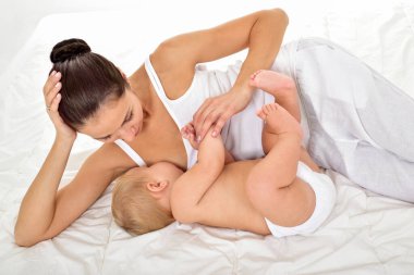 Genç anne bebeğini emziriyor. Emzirme..