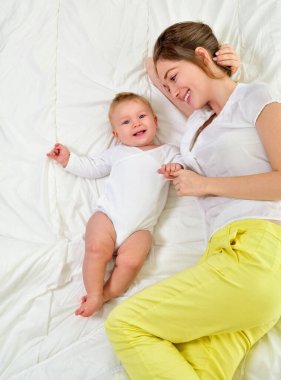 Anne ve bebek oynuyor ve gülümsüyor. Mutlu aile.