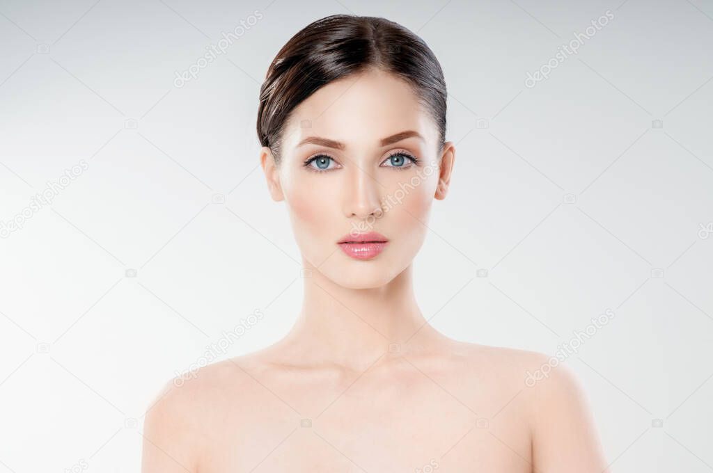 Beautiful face of young adult woman with clean fresh skin. Looking at Camera.