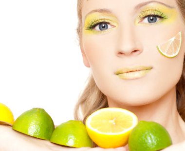 Renkli makyajlı ve elinde limon dilimi olan güzel bir kadın.