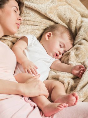 Genç anne ve bebeği, yatakta uyuyorlar.