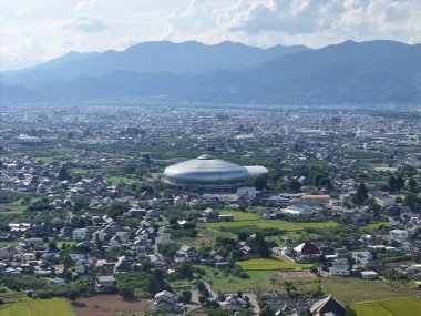 A bridge spans a river in a lush green valley. The bridge is surrounded by trees and the valley is full of greenery