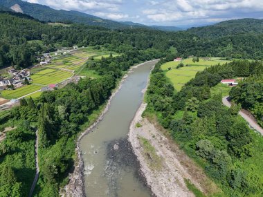 Sol kıyısında küçük bir kasabası olan yemyeşil bir vadiden bir nehir akar. Nehir sakin ve berrak, ve etrafındaki ağaçlar uzun ve yeşil. Huzurlu ve huzurlu bir sahne.