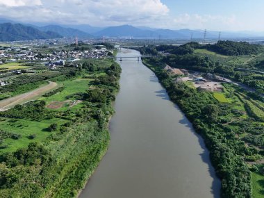 Üzerinde köprü olan bir nehir ve arka planda bir şehir. Nehir yeşil ve köprü yüksek.