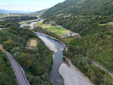 Bir nehir yemyeşil bir vadiden geçiyor. Su sakin ve berrak ve etrafındaki ağaçlar uzun ve yapraklı. Sahne huzurlu ve huzurlu, nehir huzur hissi veriyor.