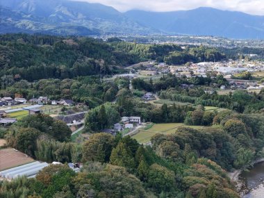 Uzakta küçük bir kasabası olan güzel bir dağ manzarası. Kasaba ağaçlarla çevrili ve huzurlu bir atmosferi var.