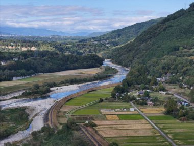 Bir nehir, sağ tarafında bir kasaba olan bir vadiden geçer. Vadi yemyeşil ve yemyeşil, etrafa dağılmış birkaç ev var. Nehir sakin ve huzurlu. Çevresindeki manzara da sakin.