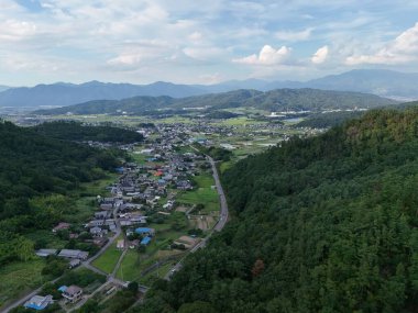 Aşağıdaki vadide bir kasabası olan bir dağ sırası. Kasaba ağaçlarla çevrili ve huzurlu bir atmosferi var.