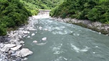 Akan nehir yemyeşil bitki ve kayalarla çevrili.