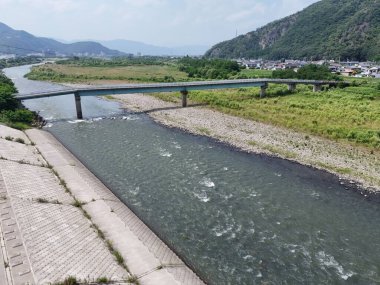 Üzerinde köprü olan bir nehir. Su akıyor ve köprü nehrin ortasında.