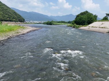 Bir sürü taş ve su olan bir nehir. Su hızlı akıyor ve kayalar nehrin dört bir yanına dağılmış.