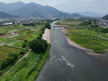 Üzerinde köprü olan bir nehir ve arka planda bir şehir. Nehir sakin ve köprü yüksek.