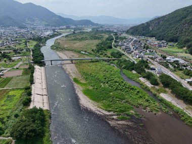 Üzerinde köprü olan bir nehir ve arka planda bir kasaba. Nehir geniş ve köprü uzun.