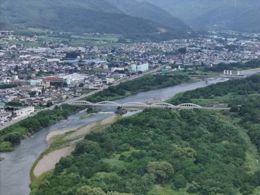 İçinden nehir akan bir şehir. Nehir yeşil ağaçlarla çevrili ve şehir binalarla dolu.
