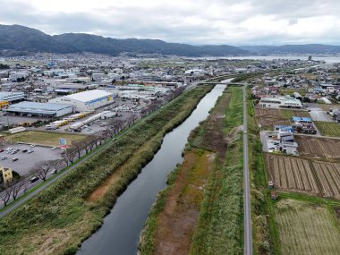 İçinden nehir akan bir şehir. Nehir yeşil bir alanla çevrilidir. Şehir araba ve binalarla dolu.