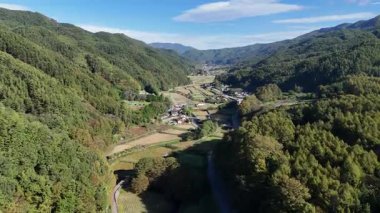 Yeşil tepelerin ve kıvrımlı nehir manzarasının havadan görünüşü