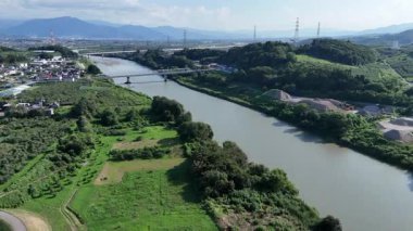 Yeşil tarlalar ve tepelerle çevrili nehrin havadan görünüşü