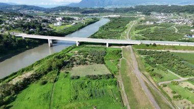 Yeşil arazi ve köprü boyunca akan nehrin havadan görünüşü